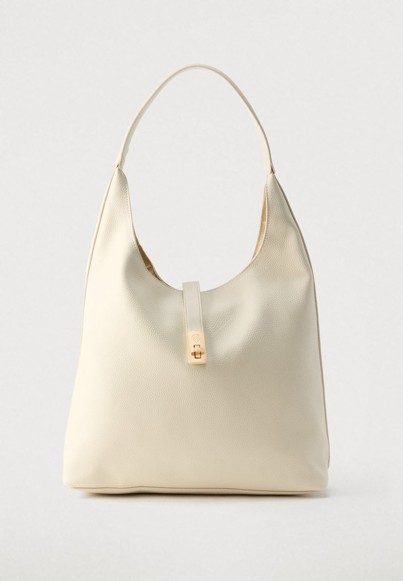 Sac hobo en cuir couleur crème avec une seule bandoulière, texture lisse et un détail de fermoir doré à l'avant.
