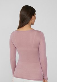 Lila shirt met lange mouwen, een getailleerde silhouet, zachte textuur en een brede halslijn, met een gladde rug en minimale naden.