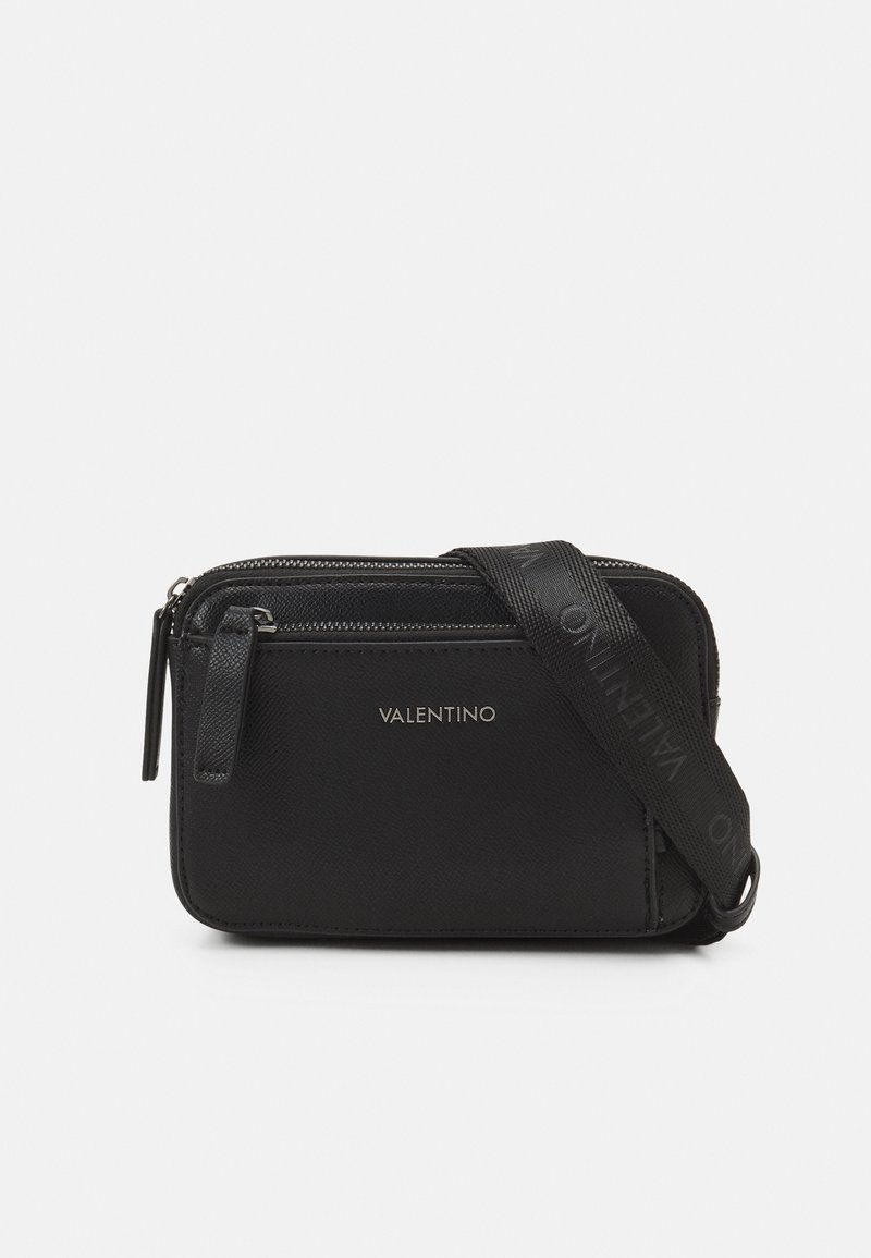 Borsa a tracolla nera in materiale sintetico testurizzato, con doppi zip, dettaglio del logo e tracolla regolabile con il nome del marchio. Design compatto e rettangolare.