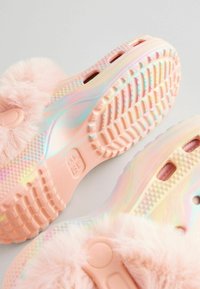 Des chaussures rose floues à enfiler avec une semelle en caoutchouc irisé. Accents en fourrure douce et motif de grip texturé sur la semelle extérieure.