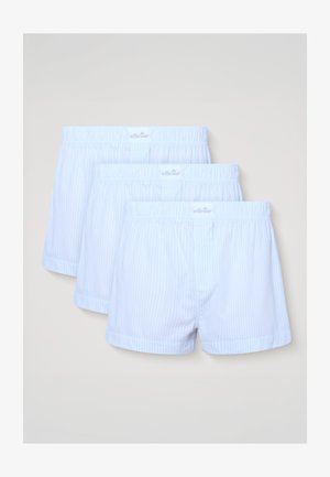 Három pár fehér boxeralsó vékony, függőleges kék csíkokkal, elasztikus derékpánttal és Ellesse logóval, egymásra helyezve, fehér háttér előtt.