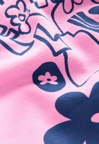 Bomuldsstof i pink med marineblå blomsterprint. Blød tekstur med glat fald, indeholdende stiliserede blomster og abstrakte former.