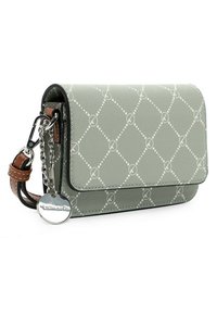 Jasnozielona mała prostokątna torba z białym wzorem w kropki w diamenty, brązowy skórzany pasek, srebrny łańcuszek i okrągły metalowy znaczek marki.