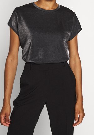 Top negro de manga corta hecho de tela brillante y texturizada con cuello redondo. Combinado con pantalones negros de talle alto.