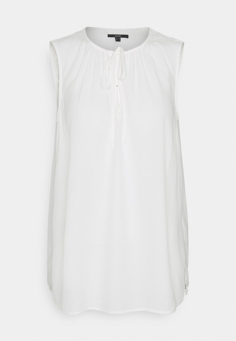 Blouse blanche sans manches avec un col rond, un détail noué à l'avant et une coupe ample.