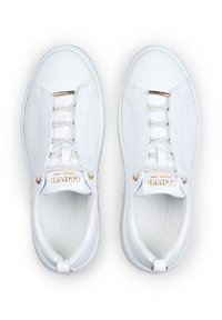 White sneakers with a smooth leather upper, elastic laces, gold accents, and a slightly textured sole. Branding visible on the tongue.