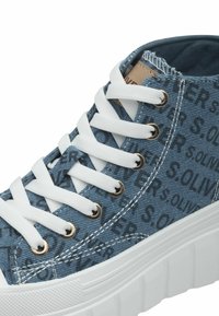 Denim high-top tenisky v modré barvě s bílými tkaničkami. Obsahují jemné vzory v černé a bílé, zlaté kovové očka a texturovanou bílou gumovou podrážku.