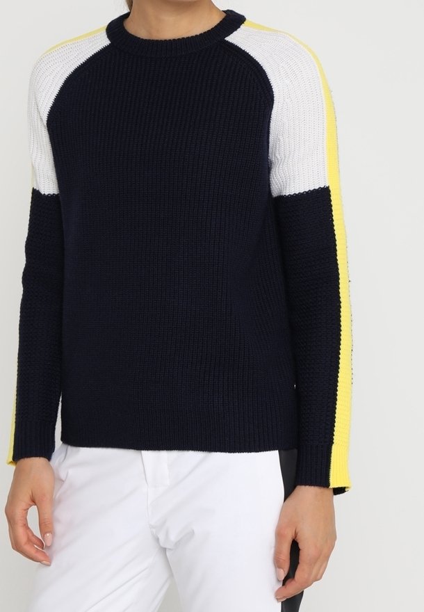 Pull en tricot bleu marine avec des manches raglan blanches et jaunes. Il présente un col rond et des poignets côtelés, offrant une finition texturée.