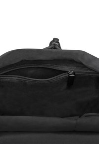 Black fabric bag interior featuring a zippered pocket, smooth texture, and a fold-over top with a cinch mechanism.