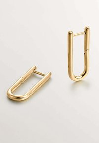 Accesorios en forma de clip de papel de metal dorado con un acabado pulido. Presentan un diseño curvado y alargado con una bisagra para abrir y cerrar.