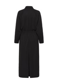 Robe midi noire à manches longues avec taille élastiquée et fente dans le dos, détail col, vue de dos sur fond blanc.