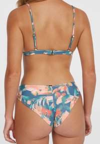 Lillelille mustriga bikiinisett, millel on sinine taust ja roosa ning roheline lillemuster; reguleeritavad rihmad ja klammerduskinnitus seljal.