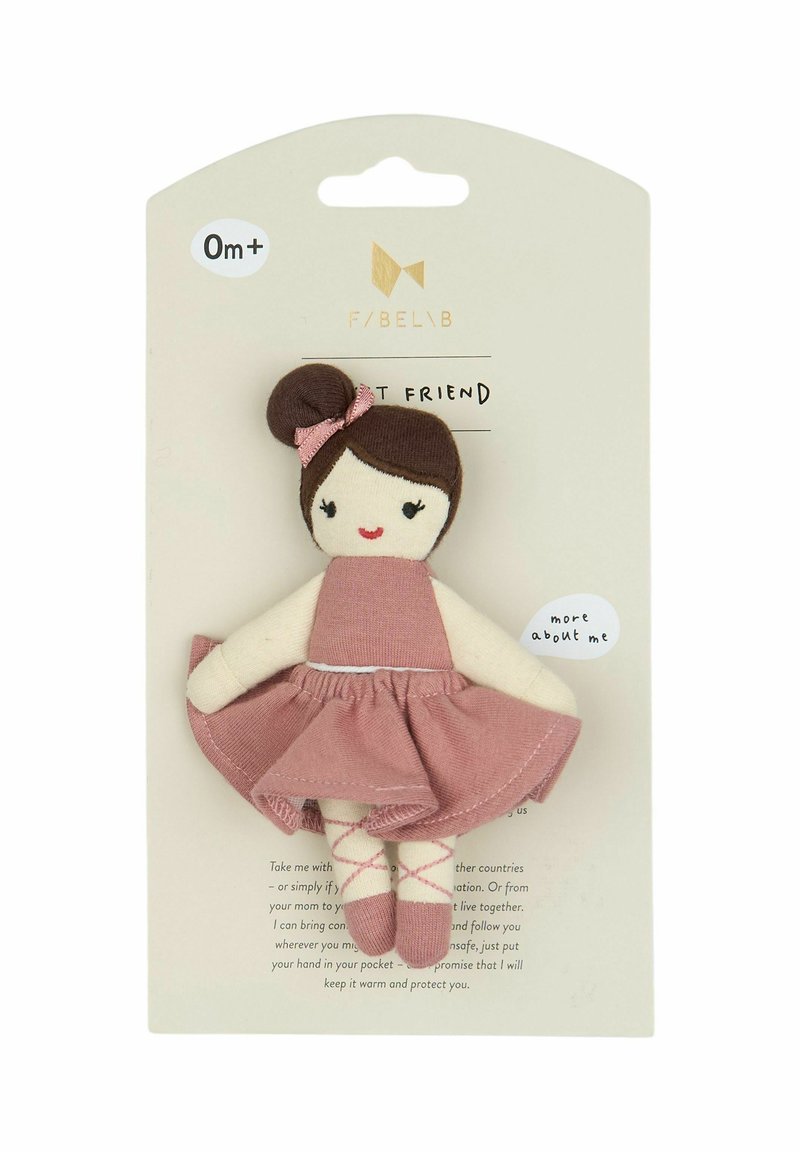 Lalka z tkaniny z brązowym kokiem, w różowej sukience i haftowanymi rysami twarzy. Kartonowe tło z nadrukowanym zaproszeniem do dowiedzenia się więcej.