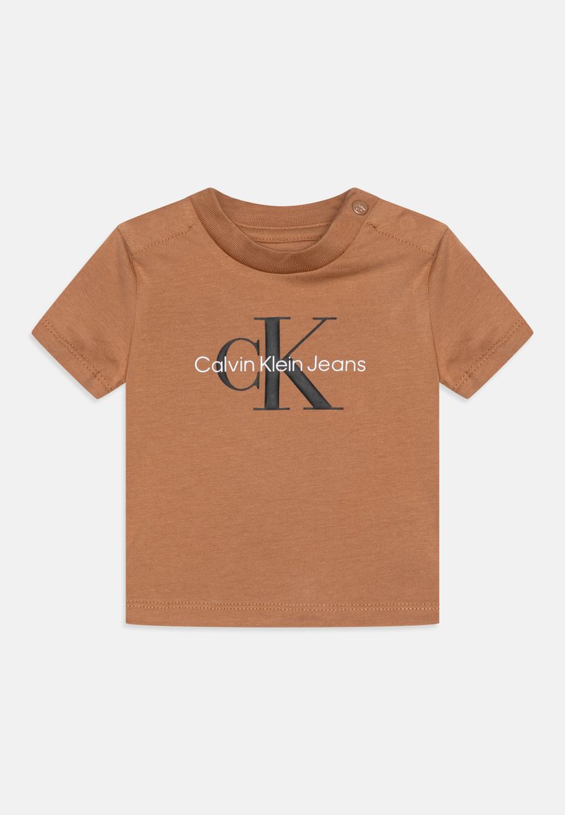 Īsām piedurknēm bērnu T-krekls brūnā kokvilnā, ar melnu "CK" logotipu un "Calvin Klein Jeans" tekstu uz priekša. Poga aizdare ap kaklu.