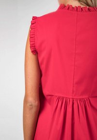 Abito fucsia con maniche a volant, cucitura posteriore arricciata e morbido tessuto di cotone. Progettato con una vestibilità ampia per il massimo comfort.
