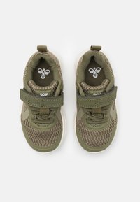 Par de zapatillas deportivas infantiles en color verde oliva con tela de malla, tiras de Velcro y suelas blancas, vistas desde arriba sobre un fondo blanco.