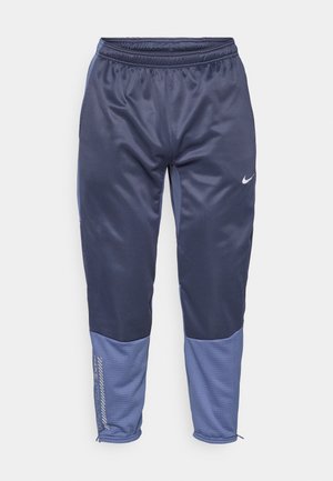 Marineblaue Trainingshose mit hellblauen Akzenten, elastischem Bund, Seitentaschen und strukturierten unteren Einsätzen. Mit kleinem Logo am Oberschenkel.