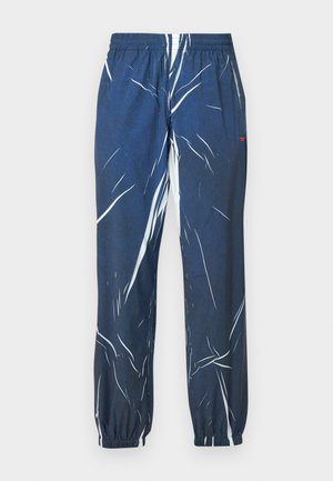 Pantaloni jogger blu con motivo a fantasia bianca astratta, vita elasticizzata e caviglie con risvolto. Realizzati in tessuto traspirante.