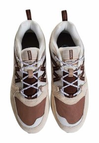 Sneakers realizzati in rete beige e suede marrone, con lacci bianchi, colletto imbottito e una linguetta con etichetta a contrasto.