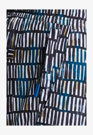 Patterned fabric with vertical black, white, and teal stripes, featuring blue zip hardware and textured accents. Close-up of pocket area.
