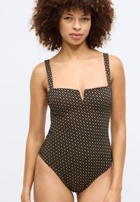 Sort badedrakt med firkantet utringning og brede stropper, med diamantmønster i beige. Glatt tekstur, tettsittende fasong og høyt snitt.