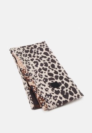 Écharpe pliée avec un imprimé léopard marron, beige et noir et une petite étiquette rectangulaire noire sur fond blanc.