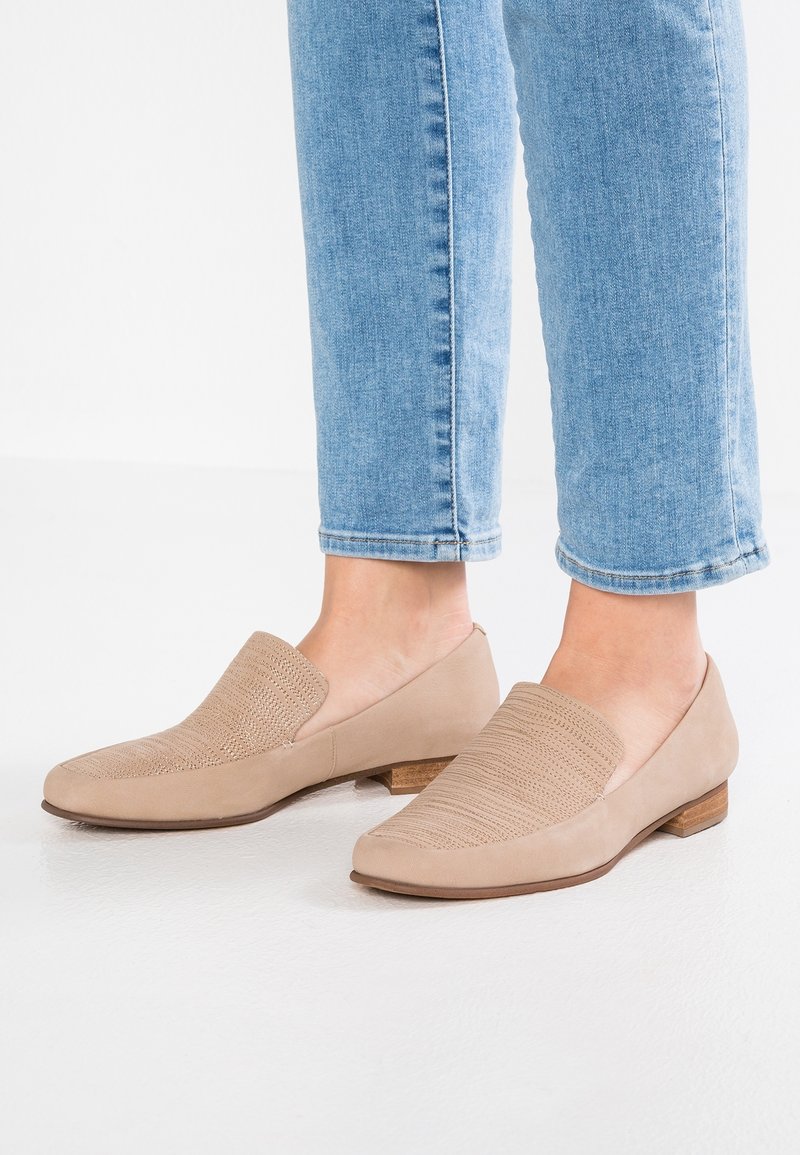 Chaussures beige à enfiler avec un motif tissé texturé sur le cou-de-pied et du cuir lisse sur les côtés, dotées d'un petit talon en bois.