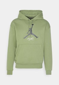 Hoodie verde con tasca frontale, cappuccio con coulisse e logo Jumpman nero con testo "Flight" sotto. Tessuto morbido e casual.