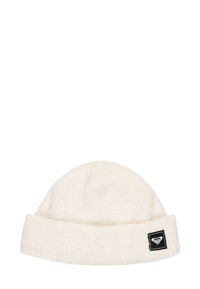Fleece beanie in cream color with a folded cuff. Features a black square patch with a white heart logo on the side. Soft, textured material.