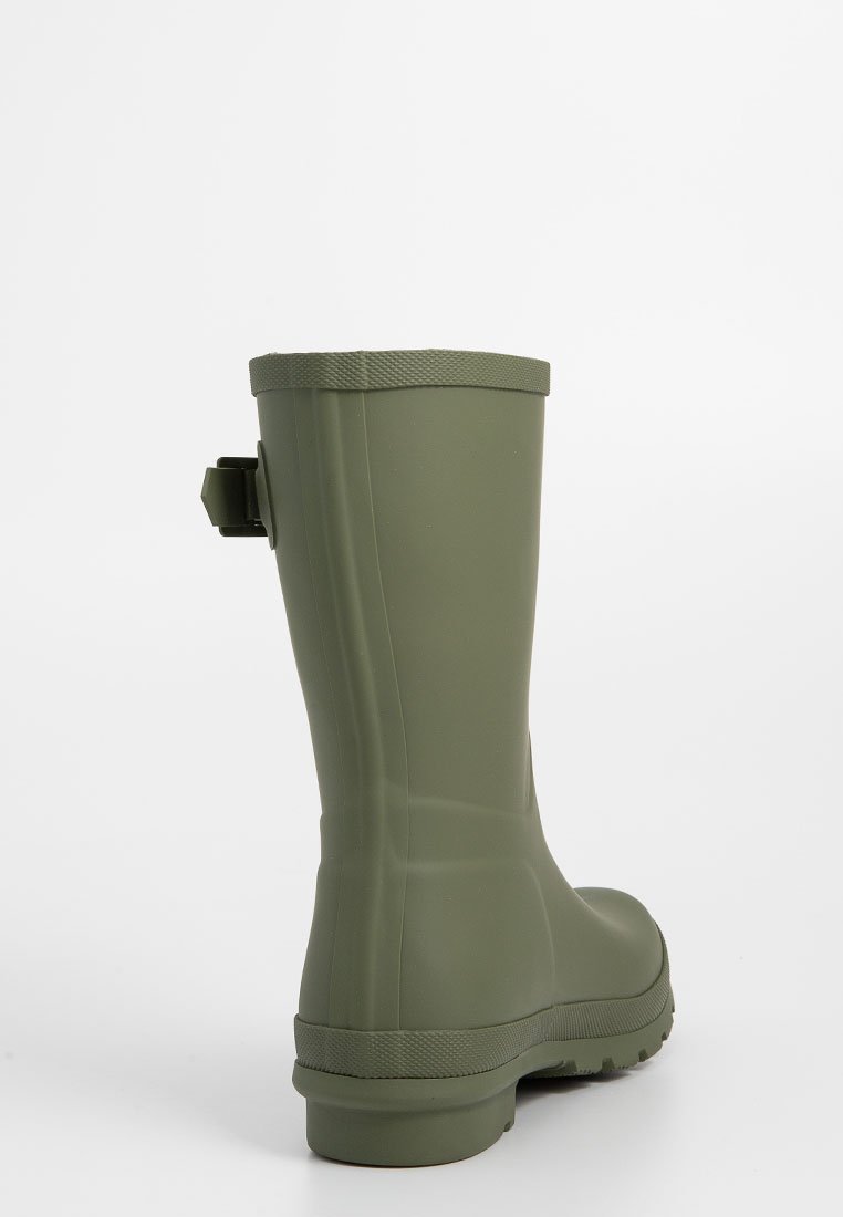 Bota de goma verde con una textura suave, punta redonda y suela antideslizante. Cuenta con una lengüeta en la parte trasera para facilitar su uso.