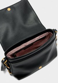 Borsa a mano in pelle nera con finitura texturizzata, hardware dorato e apertura superiore che rivela un interno rosa chiaro con un motivo logo sottile.
