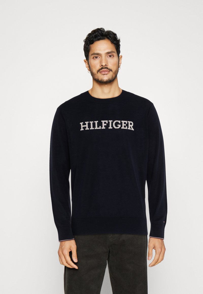 Maglione a maniche lunghe blu navy con la scritta grigia "HILFIGER" sul petto. Collo e polsini a coste, tessuto morbido con una superficie liscia.