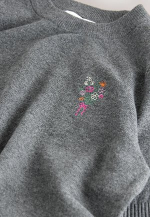 Grauer Strickpullover mit Rundhalsausschnitt und gerippten Bündchen. Mit buntem floralem Stickerei im Bereich der linken Brust. Weicher Stoff.