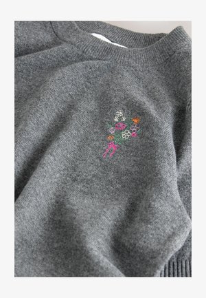Grauer Strickpullover mit Rundhalsausschnitt und gerippten Bündchen. Mit buntem floralem Stickerei im Bereich der linken Brust. Weicher Stoff.