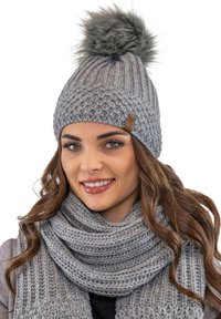 Beanie in maglia grigia con un morbido pon-pon sulla sommità, caratterizzato da un design testurizzato. Abbinato a una sciarpa grigia spessa e abbinata, anch'essa testurizzata.