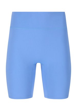 Gros plan d'une personne portant des leggings bleu clair taille haute, montrant la taille, le ventre et une partie de la main droite.