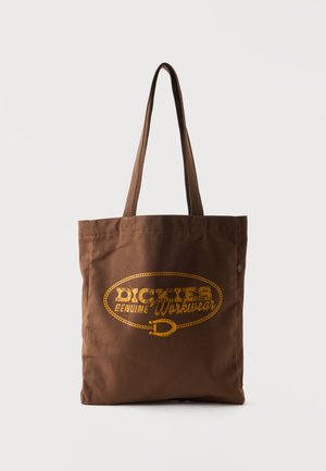Bolsa tote de tela marrón con asas largas y logo amarillo de "Dickies Genuine Workwear" impreso en el frente.