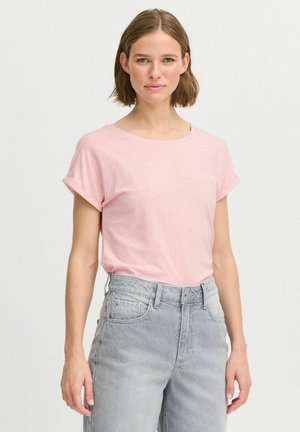 Różowy t-shirt z krótkim rękawem, okrągłym dekoltem, miękką strukturą i podwiniętymi mankietami, w połączeniu z jasnoszarymi dżinsami z wysokim stanem.