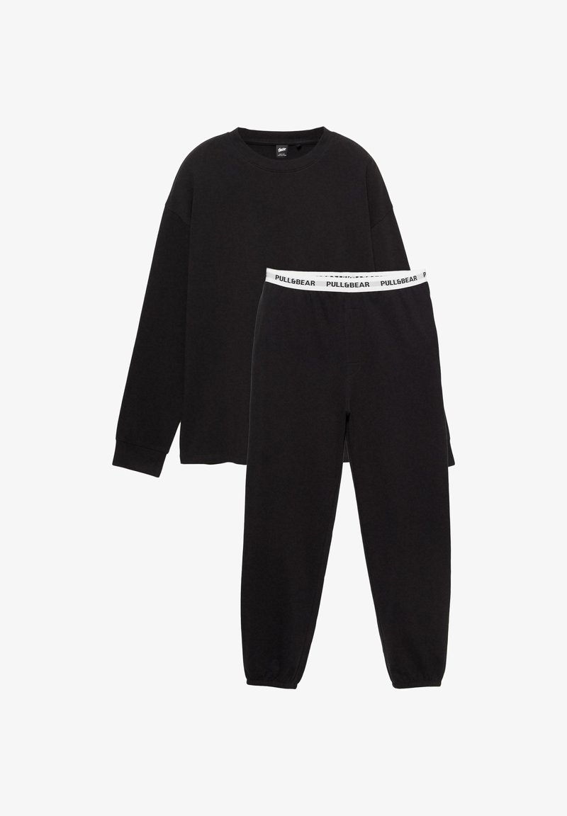 Set di abbigliamento lounge nero composto da una maglia a maniche lunghe con collo rotondo e pantaloni coordinati con vita elasticizzata bianca con logo. Tessuto morbido, vestibilità rilassata.