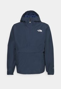 Giacca pullover blu navy con zip frontale, cappuccio e logo sul petto; realizzata in materiale leggero e resistente all'acqua con polsini elasticizzati.