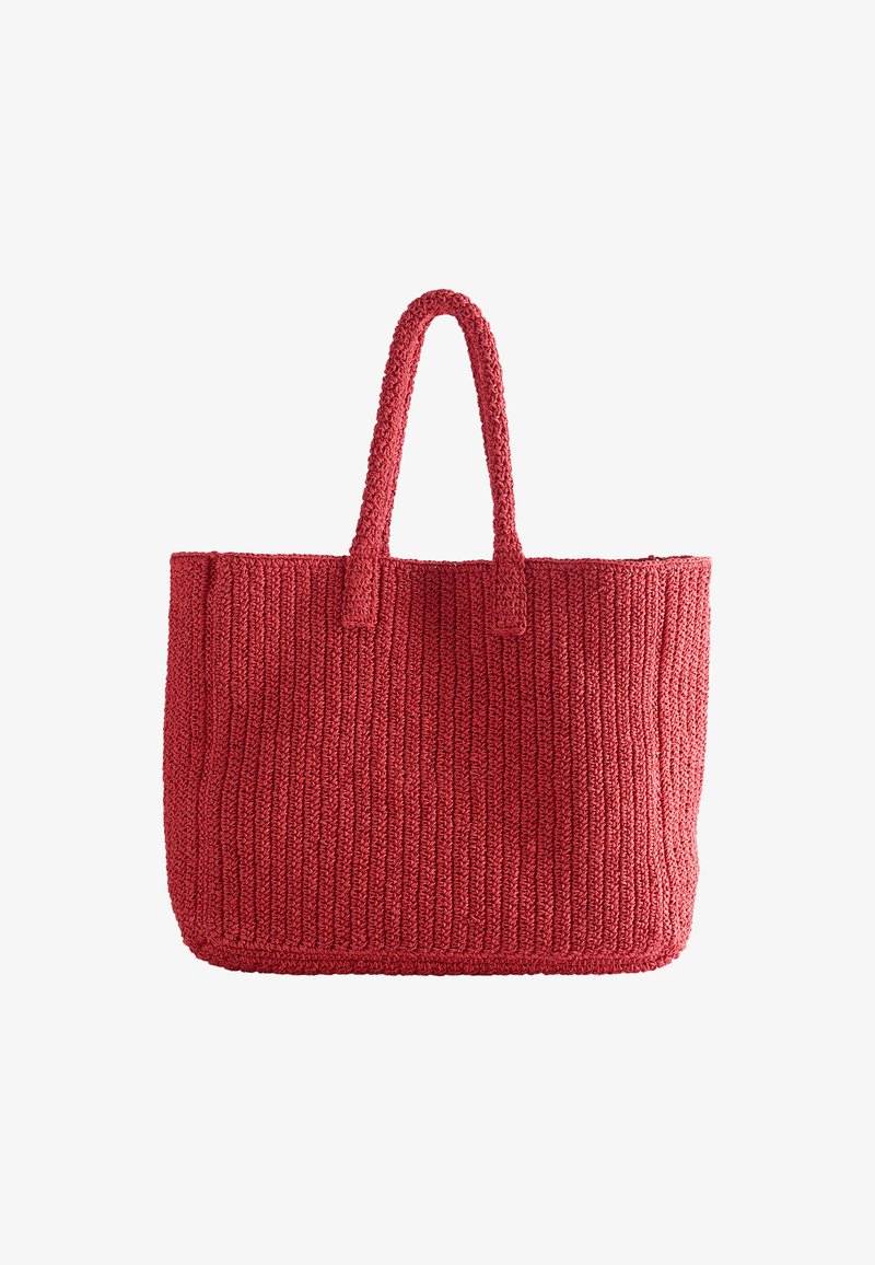 Sac cabas en tricot rouge avec deux anses, forme rectangulaire et motif côtelé vertical texturé, sur fond blanc.