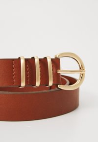 Brown leather belt featuring a smooth texture, gold metal buckle with a rounded design, and three metallic loops for adjustable sizing.