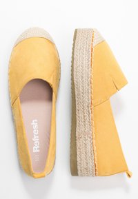 Gule ruskind espadriller med sål af jute reb, mandelformet tå og en let hæl. Har et slip-on design med syede detaljer.
