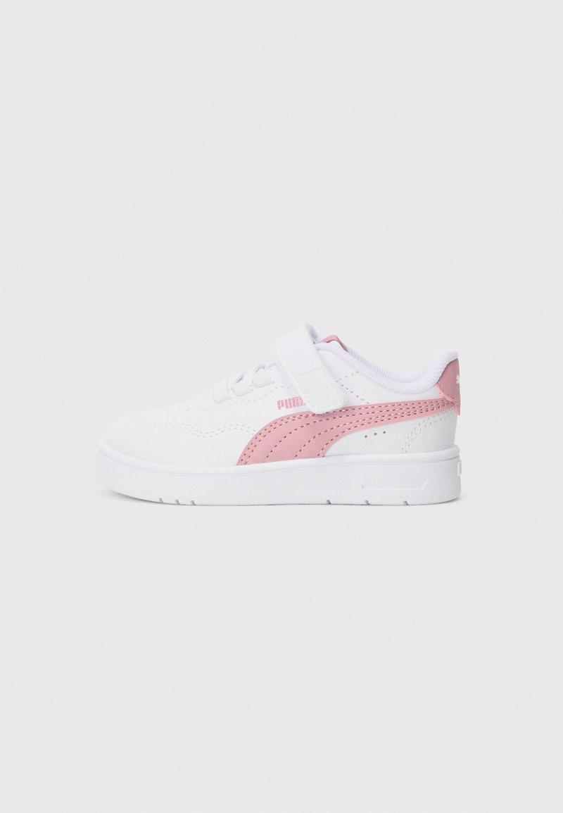 Zapatillas blancas con un panel lateral rosa, tira de Velcro y acentos texturizados. Punta redondeada y suela de goma plana para estabilidad.