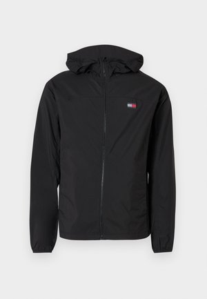 Črna lahka jakna z zadrgo spredaj, kapuco in elastičnimi manšetami. Na levi prsni strani ima našitek z logotipom. Gladek tekstura.