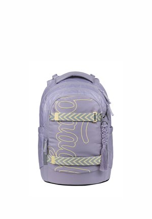 Hellvioletter Rucksack mit gelber, bestickter kursiver Schrift, zwei chevronmusternden horizontalen Gurten, Seitentaschen und einem geflochtenen Quasten-Schlüsselanhänger.