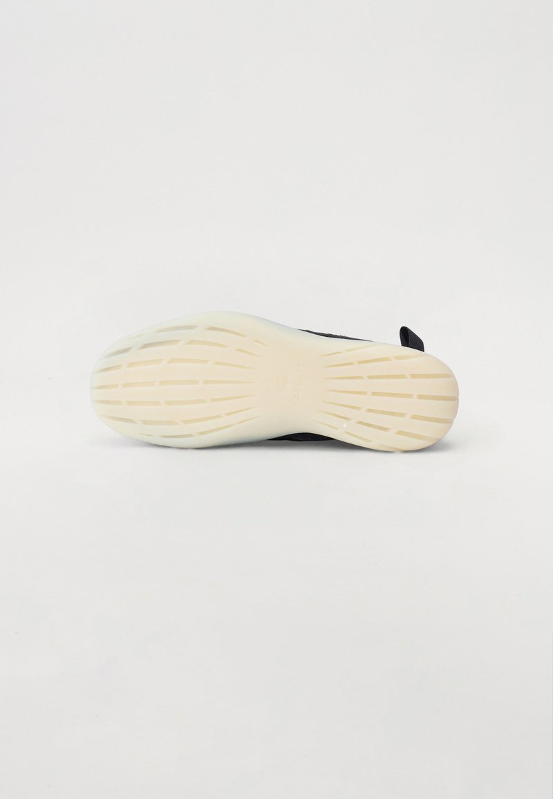 Baskets noires avec une tige texturée, dotées d'une semelle en caoutchouc blanche avec un motif de bande de roulement, conçues pour l'adhérence et la durabilité.