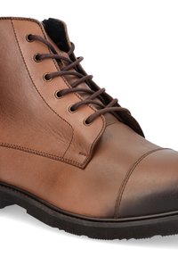 Brązowy skórzany botek za kostkę z okrągłym noskiem, z przodu sznurowany, z złotymi oczkami i fakturowaną cholewką. Gruba gumowa podeszwa zapewniająca przyczepność.