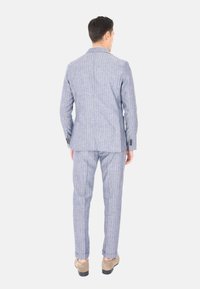 Abito leggero azzurro e bianco a righe con una vestibilità su misura. Presenta un rever a punta e pantaloni slim con risvolti.