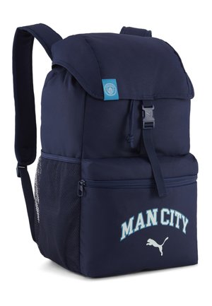 Granatowy plecak z klapką i klamrą, siateczkową boczną kieszenią, przednią kieszenią na zamek, napisem "MAN CITY" oraz logo Puma na przedniej kieszeni.